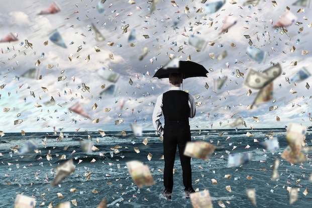 Sergey Nivens / Shutterstock | https://www.shutterstock.com/pic-108174599/stock-photo-young-businessman-standing-with-umbrella-under-money-rain.html