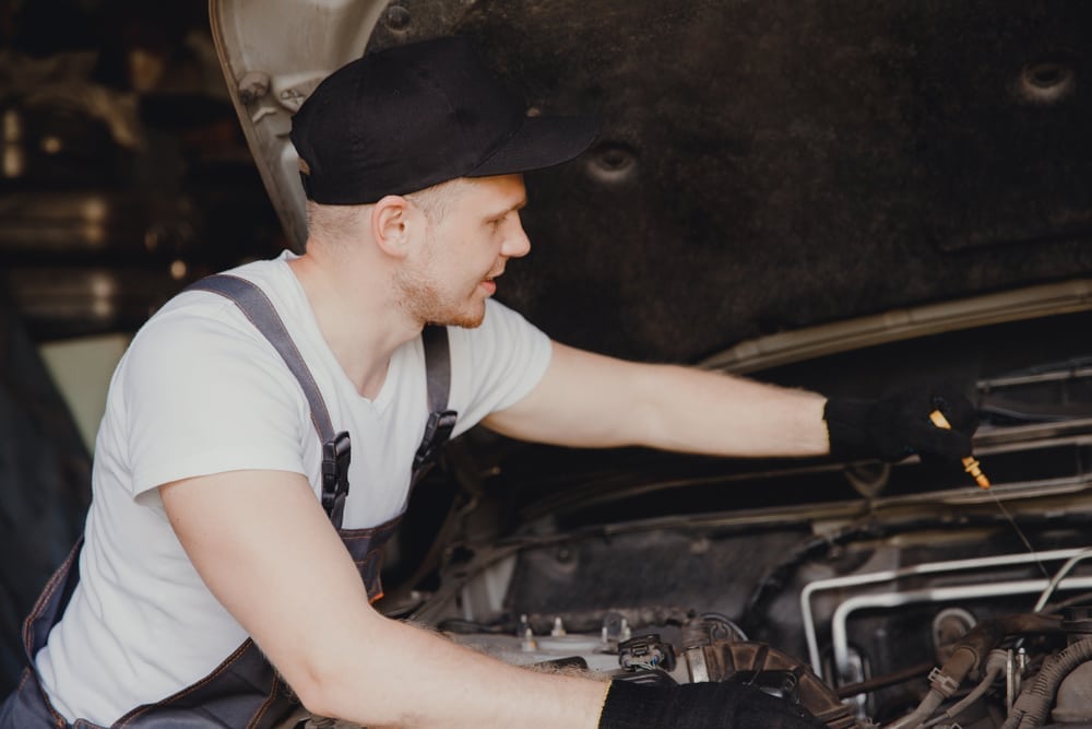 How to Pay for an Expensive Car Repair - Car Mechanic Diagnosing A Car Repair